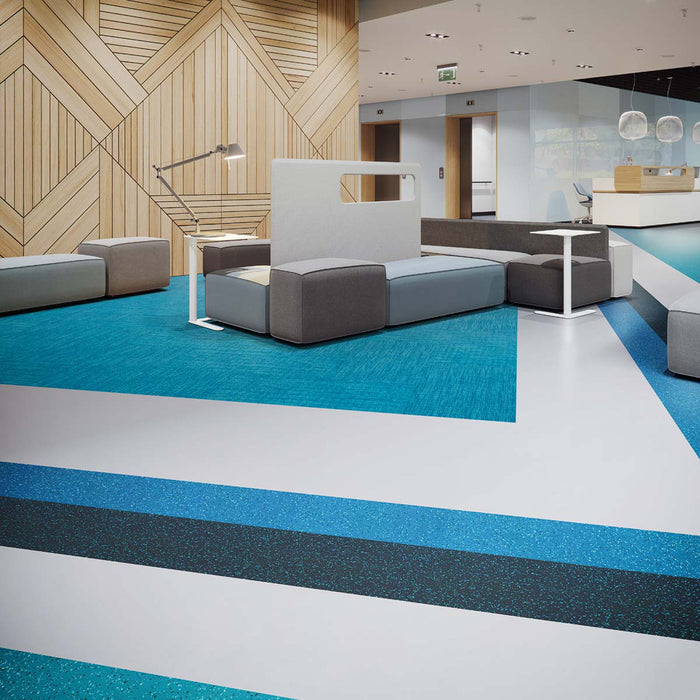 Modern interior with lounge seating, wood panel walls and blue and gray sculptured rubber tile flooring from the Burke ColorScape collection